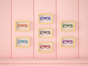 colourful glasses in yellow frames hanging on pink wall