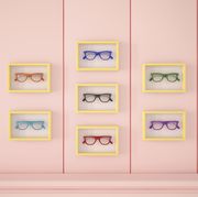 colourful glasses in yellow frames hanging on pink wall