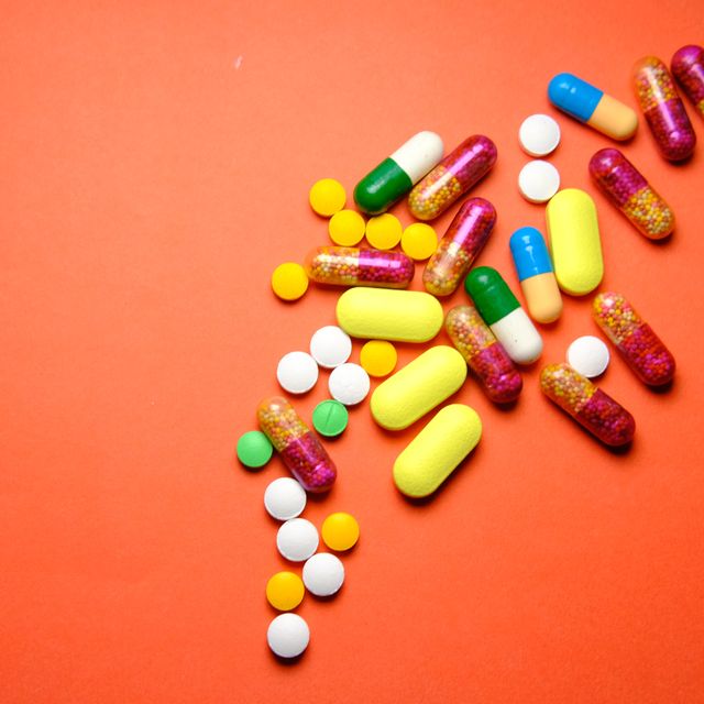 colourful pills spilled on blue background.