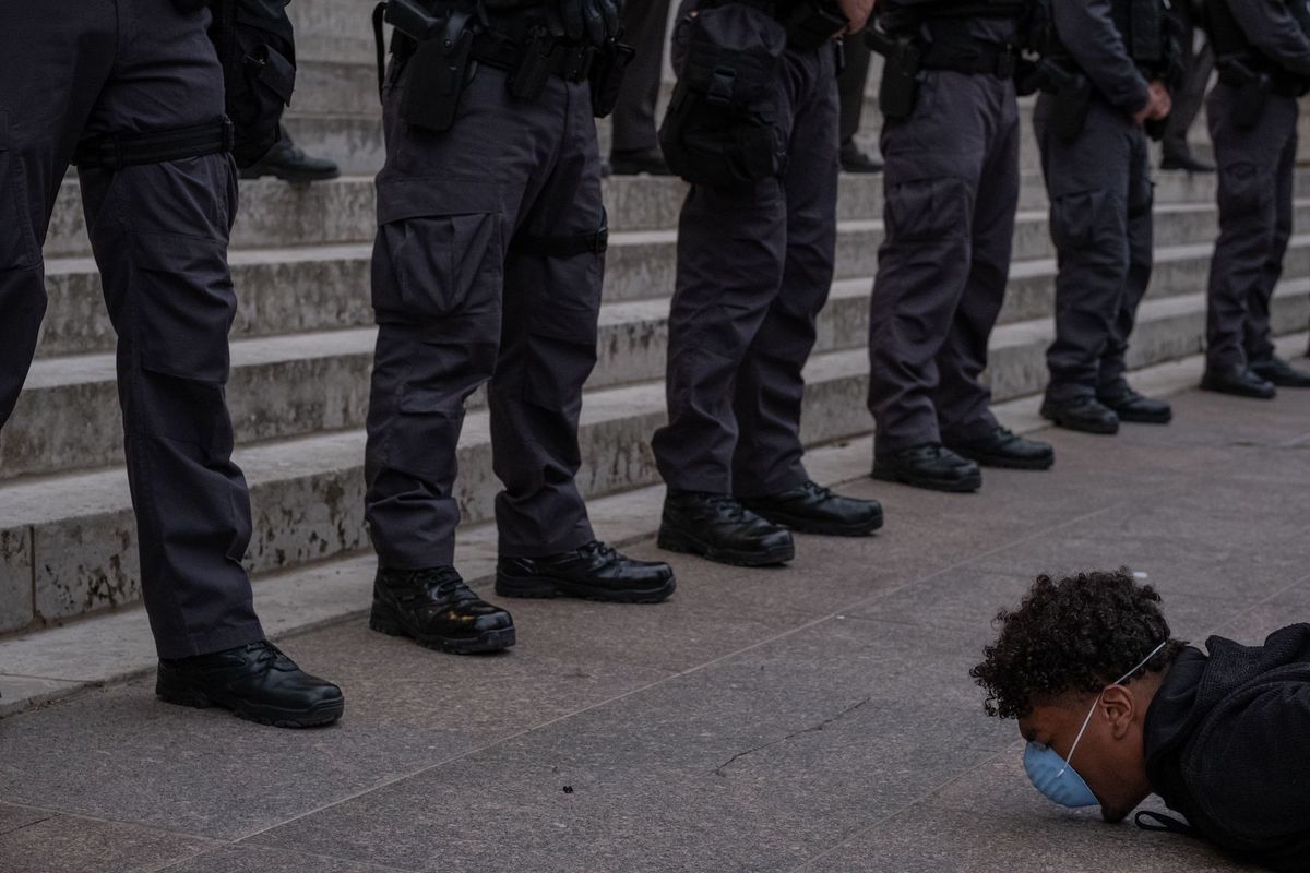 topshot   a protester holds a die in in front of a row of police officers during a peaceful protest over the death of george floyd at the state capital building in downtown columbus, ohio, on june 1, 2020   columbus, ohio is under a city wide curfew starting 1000pm major us cities    convulsed by protests, clashes with police and looting since the death in minneapolis police custody of george floyd a week ago    braced monday for another night of unrest more than 40 cities have imposed curfews after consecutive nights of tension that included looting and the trashing of parked cars photo by seth herald  afp photo by seth heraldafp via getty images