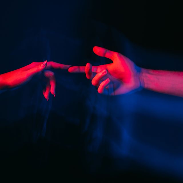 love power romantic couple affectionate feelings happy meeting sensual male and female hands reaching together on blue red neon light blur long exposure isolated black