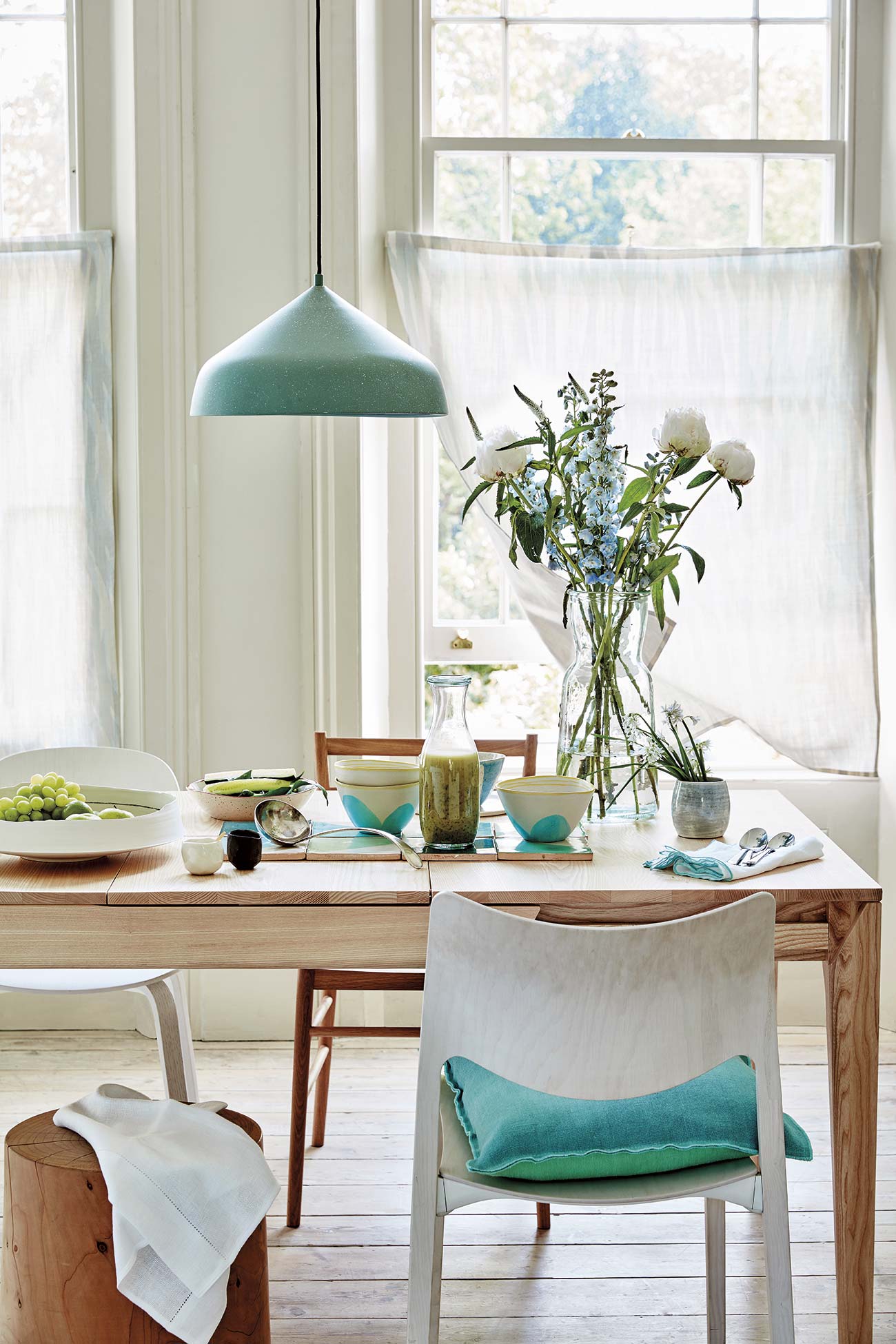comedor con mesa de madera y lámpara de techo verde