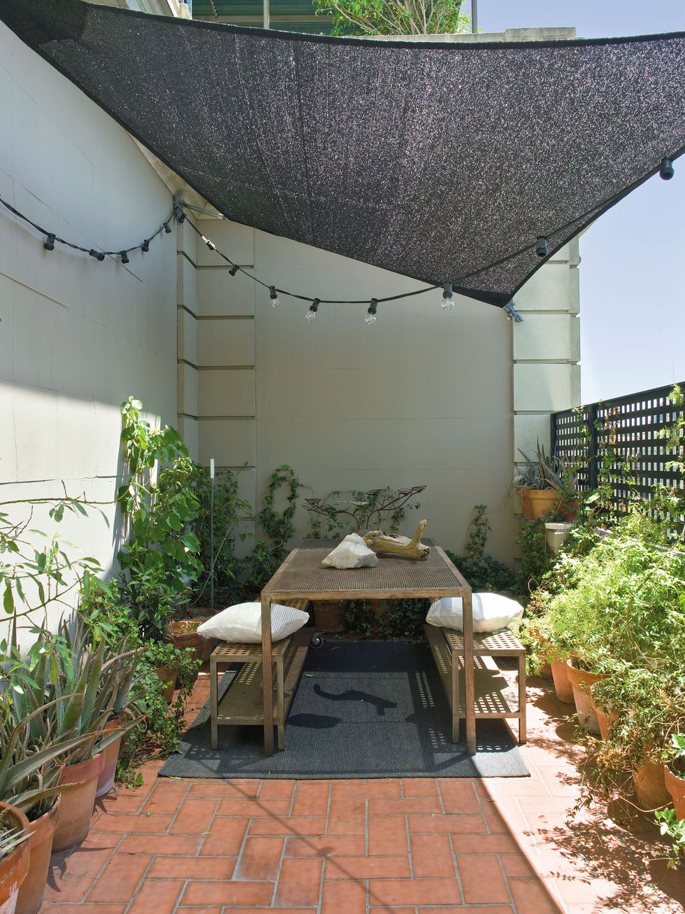 an outdoor dining room on a terrace with a floor and awning