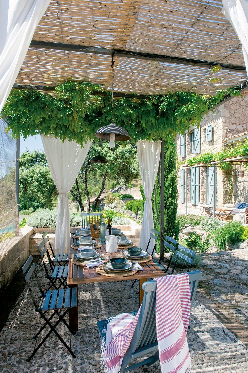 an outdoor dining room with curtains
