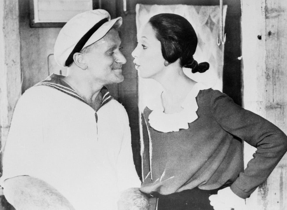 robin williams and shelley duvall stand and look at each other while filming for popeye