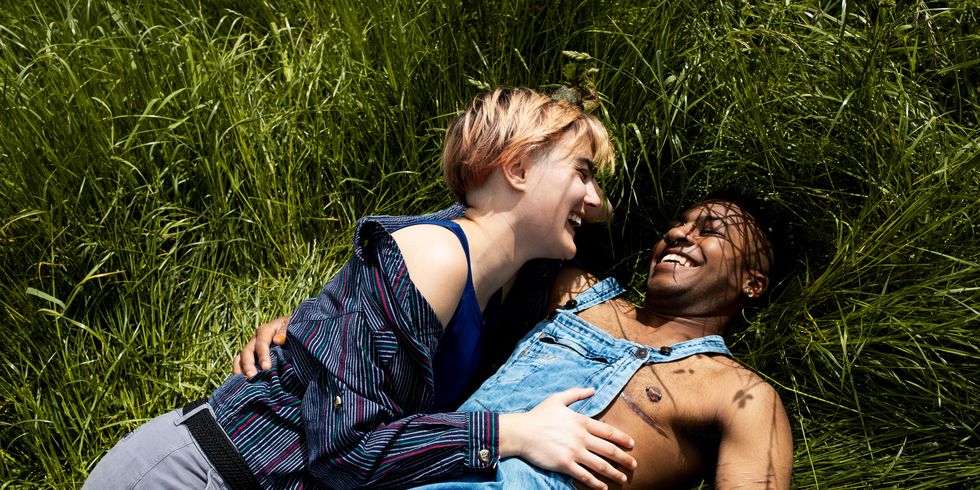 a happy couple lying in the grass