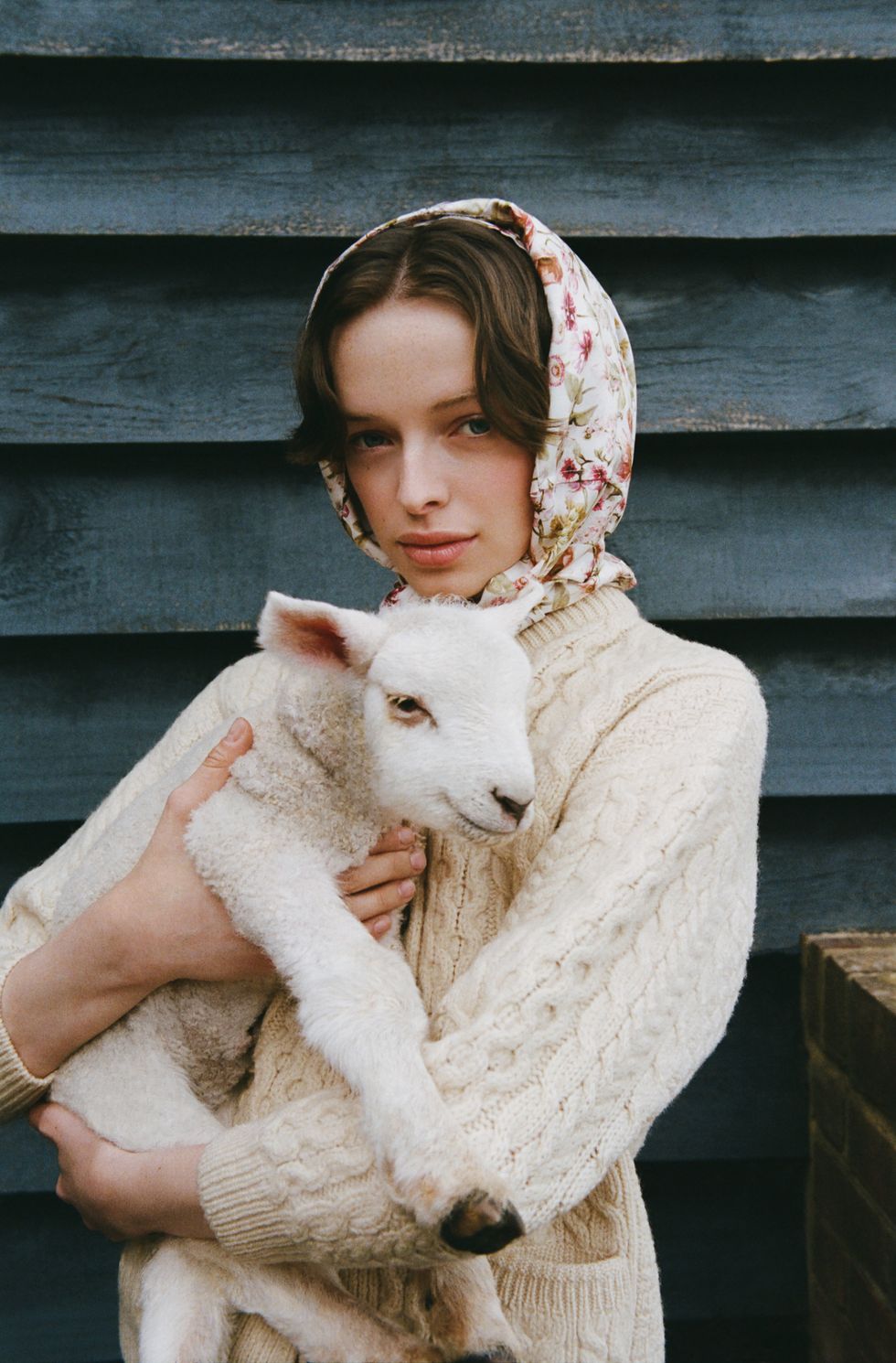 a woman holding a white lamb