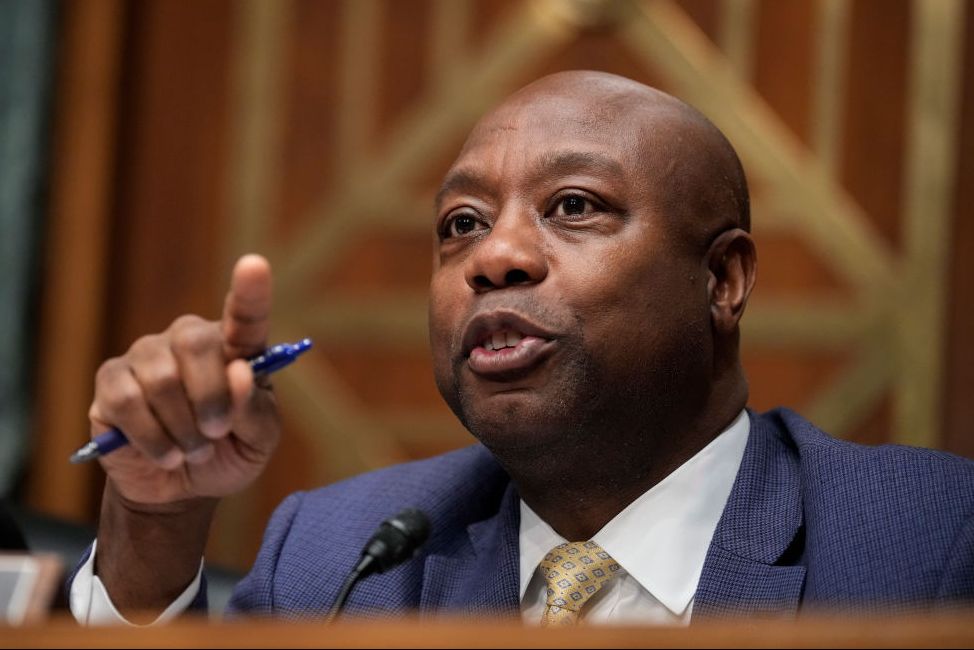 tim scott pointing while holding a pen in his right hand and speaking to someone off camera