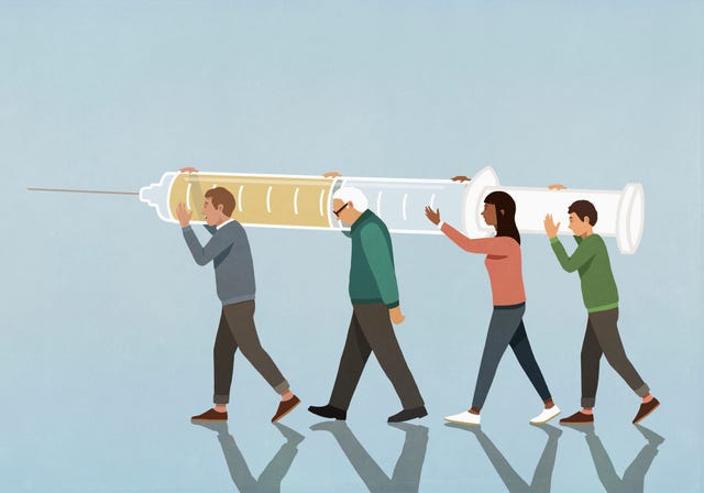 community carrying large vaccination syringe