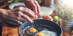 manos de mujer haciendo huevos fritos