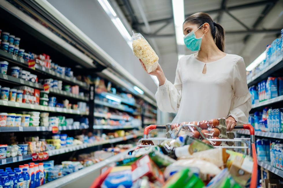 mujer haciendo la compra con mascarilla en el supermercado