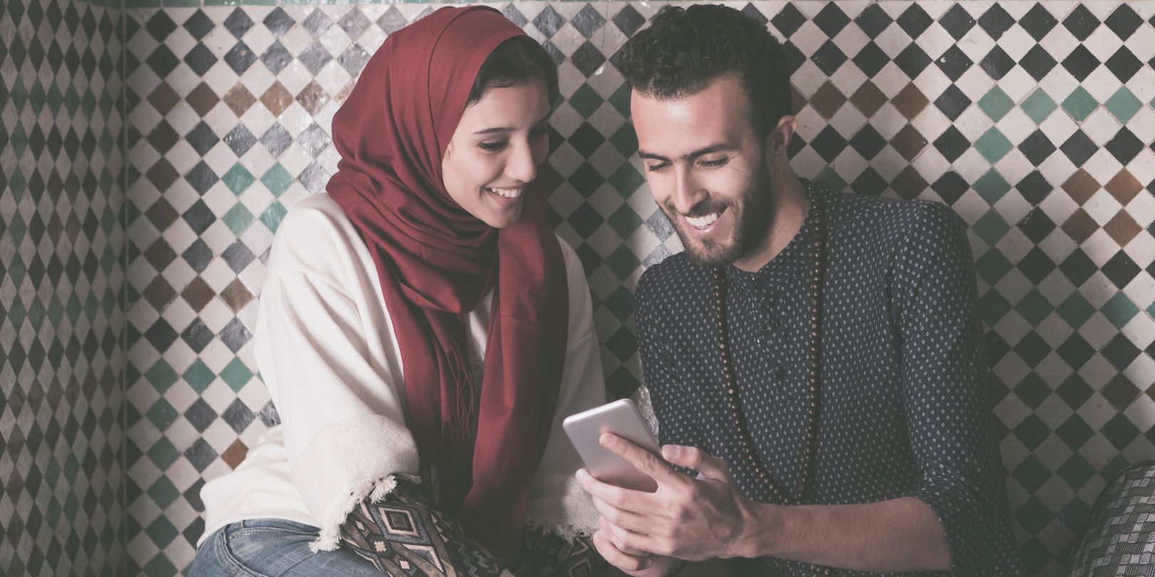 a couple smiling and looking at a phone
