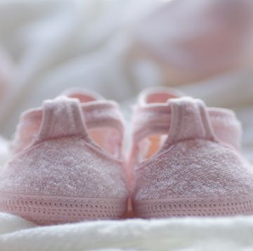 small pink shoes on a white blanket