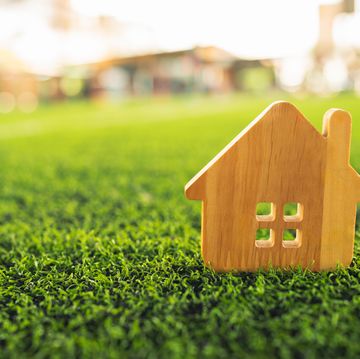 concept of wood house on green grass , a symbol for construction , ecology, loan, mortgage, property or home.