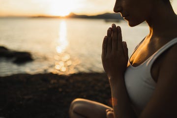 a woman with prayer hands practicing yoga and meditation