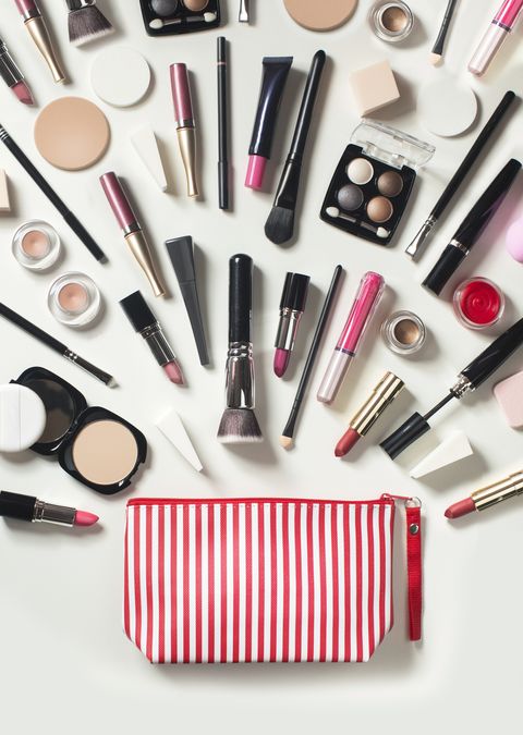 make up bag with a variety of products like a brush, bronzer, lipstick