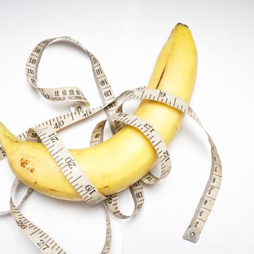 conceptual illustration for penis size, banana with plastic tailor meter on white background