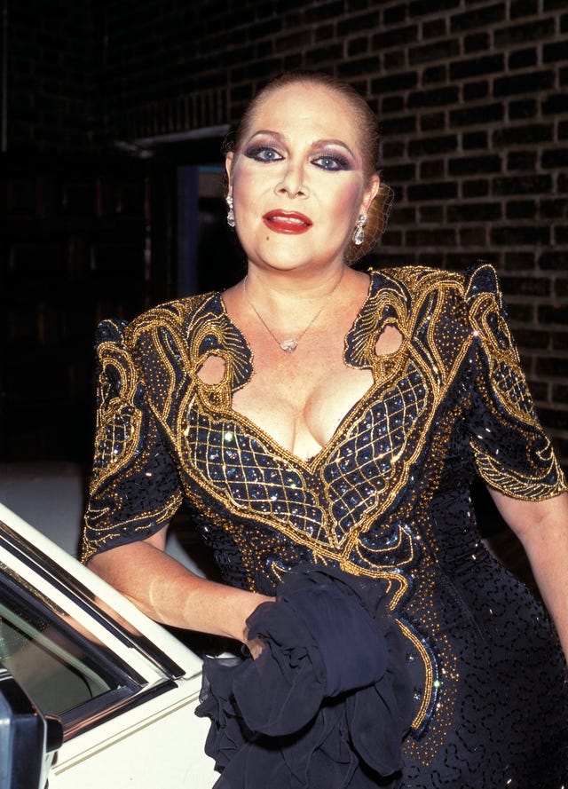 la cantante, muy guapa, con un vestido de noche de brillos en negro y dorado