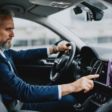 conectar coche teléfono móvil un hombre consulta su teléfono móvil dentro del coche
