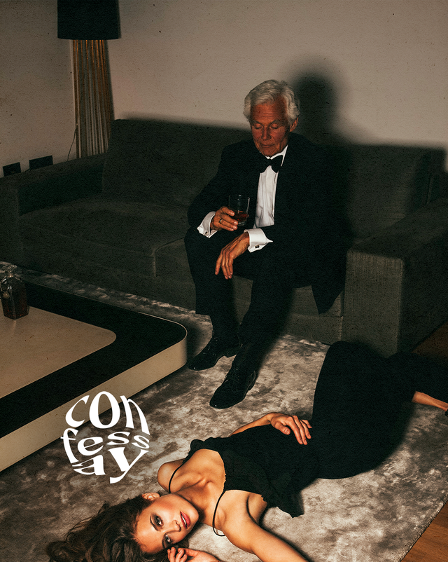 a man sitting on a couch with a woman lying on the floor in front of him