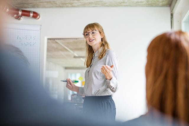 Confident businesswoman giving presentation to colleagues in office