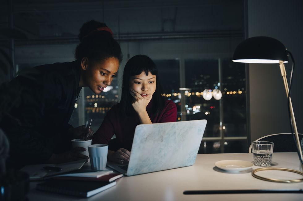 confident businesswomen planning strategy while using laptop in night meeting at office