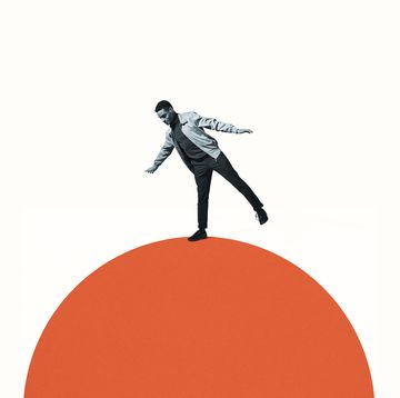 confident man balancing on orange semi circle