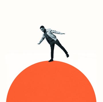 confident man balancing on orange semi circle