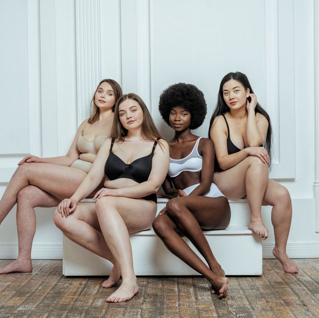 group of models in lingerie  sitting against white wall