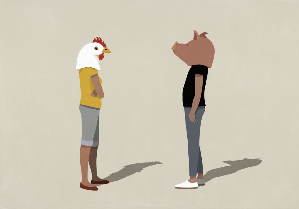 confrontational couple in pig and chicken heads standing face to face