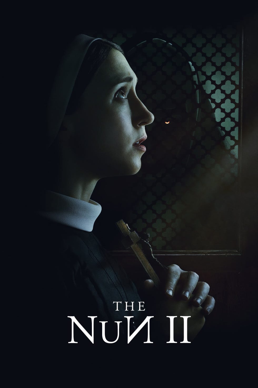 a nun prays while a demon lurks in the background in a poster for the nun 2