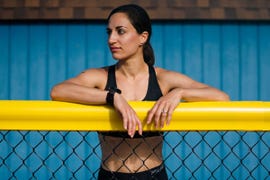 una deportista apoyada sobre una red de metal