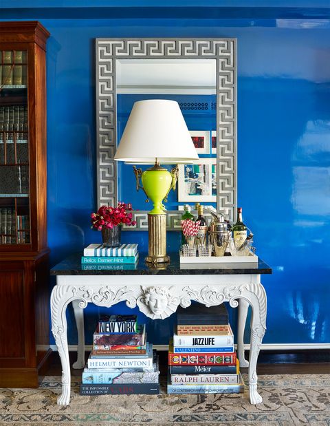 room with blue lacquered walls and mini bar on console table