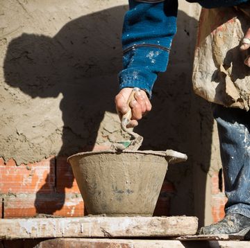 construction worker placing cement with a trowel on the wall