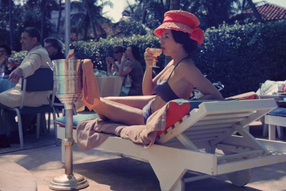 mujer tomando un cóctel en la piscina del hotel colony palm beach florida