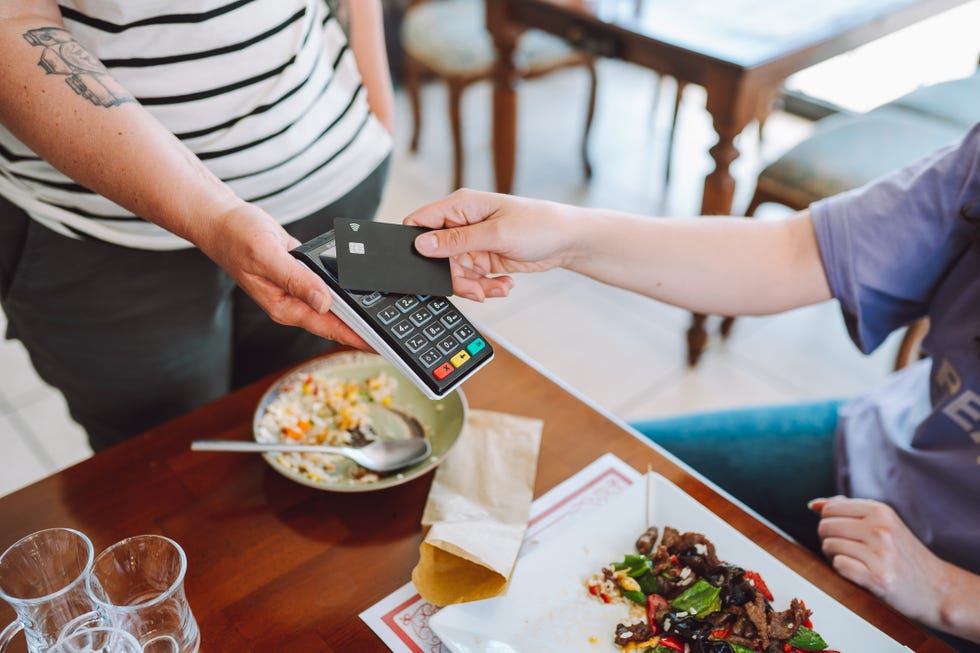 contactless payment in restaurant, wireless card reader for scanning credit card from customer's hand in cafe, view from a high angle