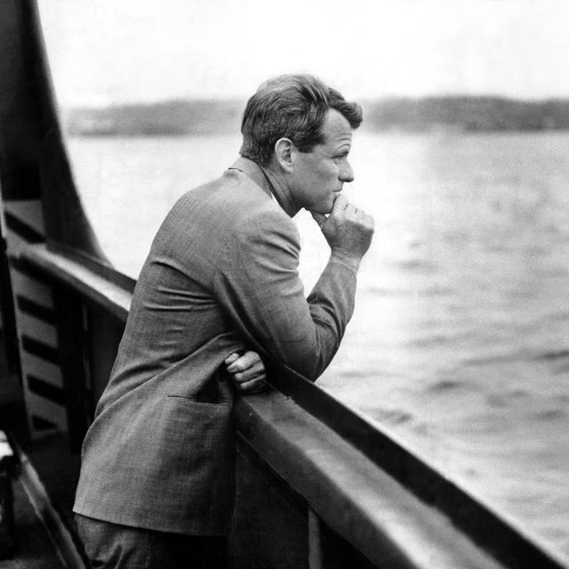A contemplative Robert F. Kennedy leans on the railing of a