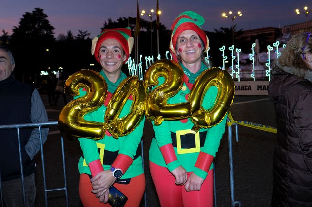 dos chicas disfrazadas de elfos verdes con dos globos de 2020 durante la carrera de la san silvestre vallecana del pasado año