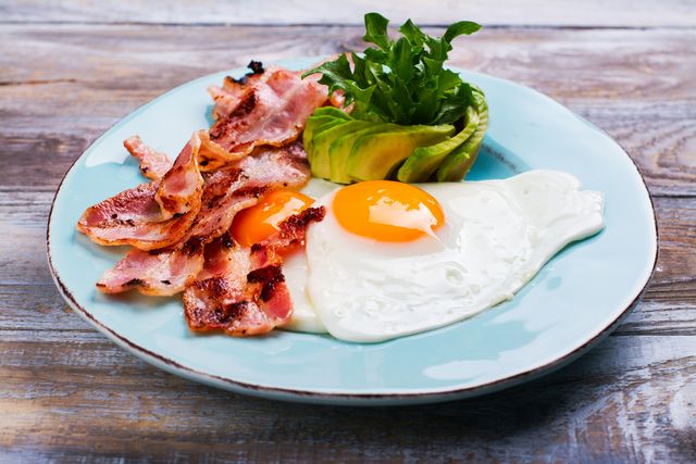 Continental breakfast with fried eggs, bacon and avokado