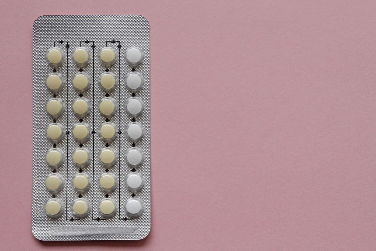 contraceptive pills in blister pack on pink background