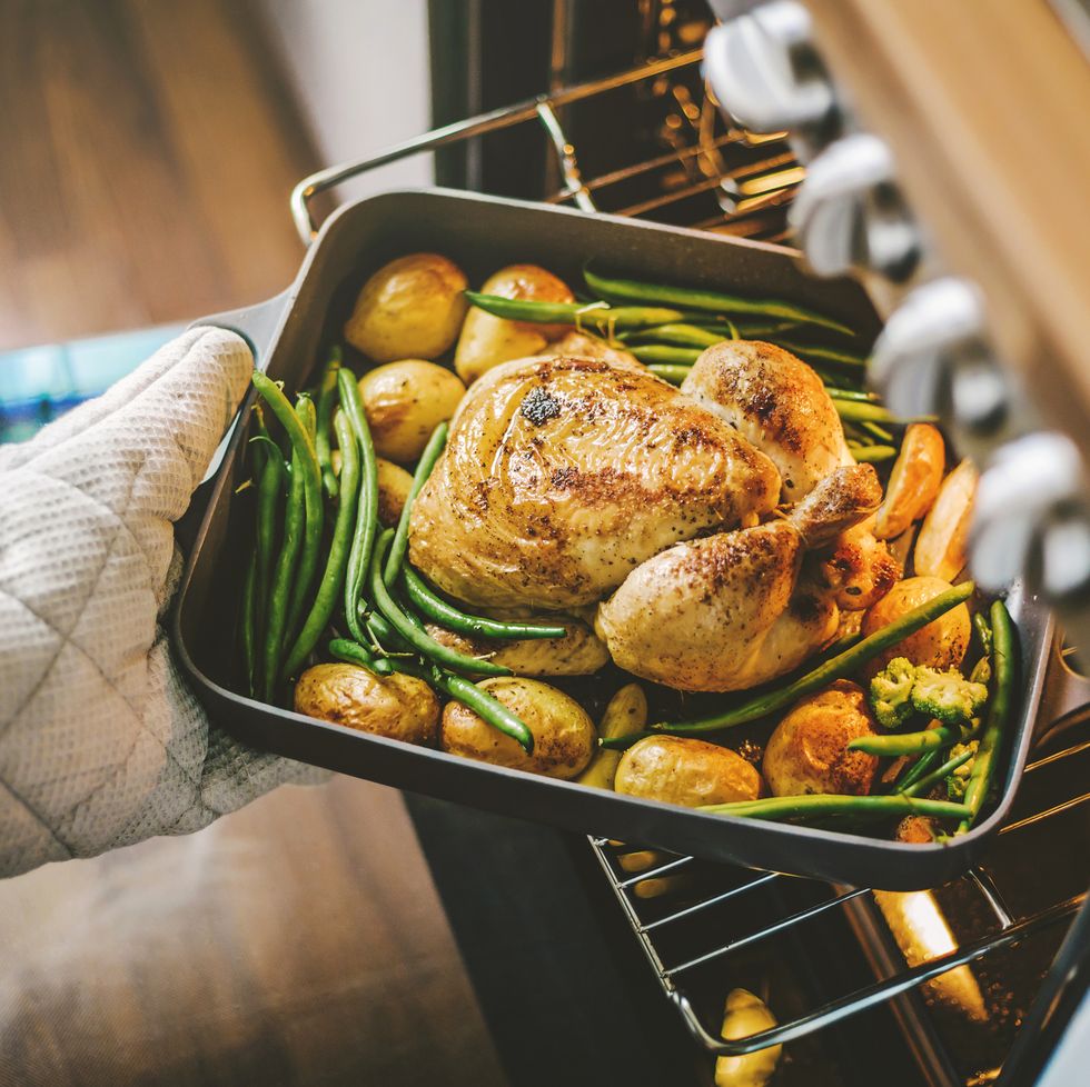 cook taking ready chicken from the oven