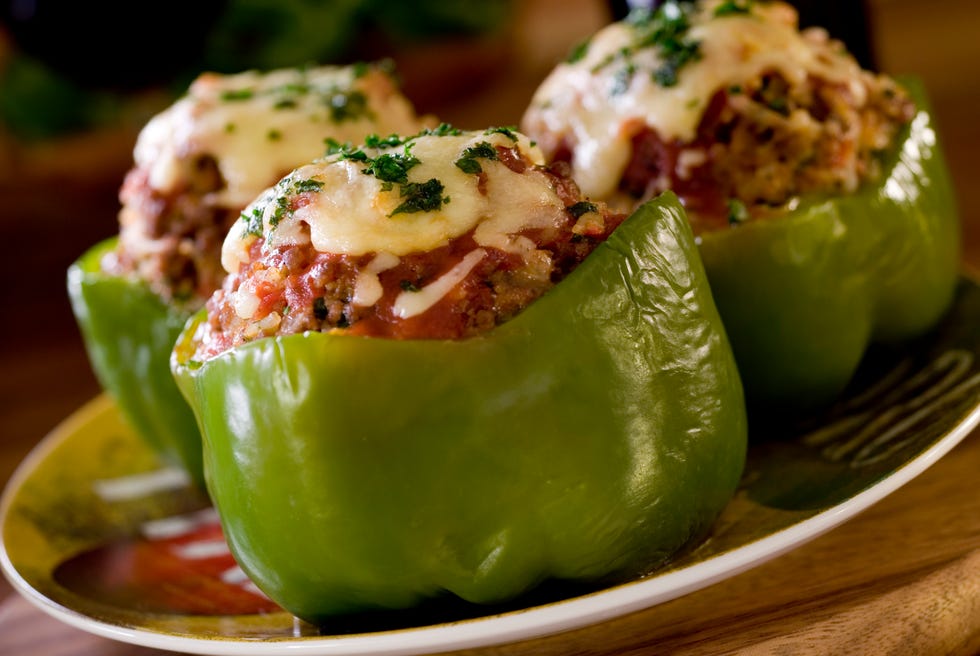 Cooked green bell peppers stuffed and topped with cheese