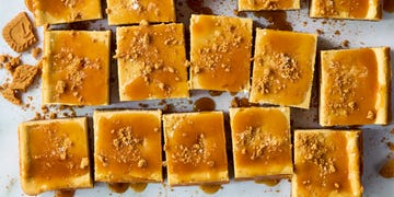 cheesecake bars topped with caramel and crumbled biscoff cookies