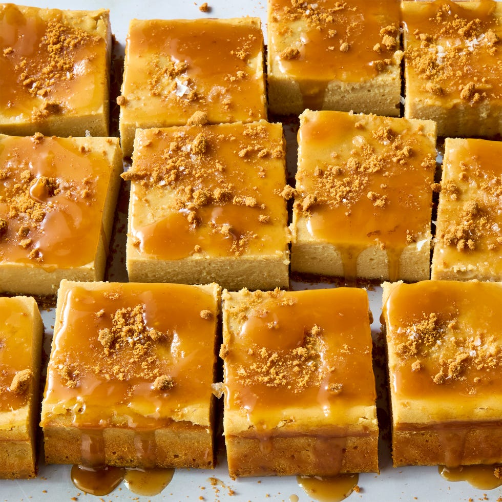 cheesecake bars topped with caramel and crumbled biscoff cookies