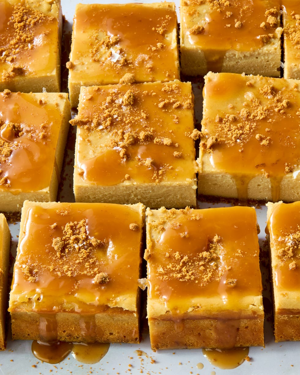 cheesecake bars topped with caramel and crumbled biscoff cookies