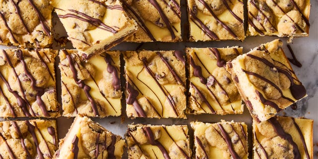 cheesecake bars with a cookie bottom and top layer drizzled with chocolate