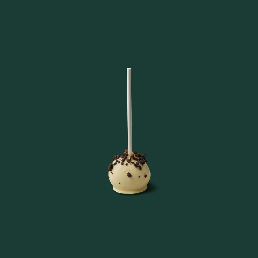 dessert on a stick coated with white chocolate and topped with chocolate crumbs