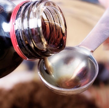 close up of medicine being poured onto a teaspoon