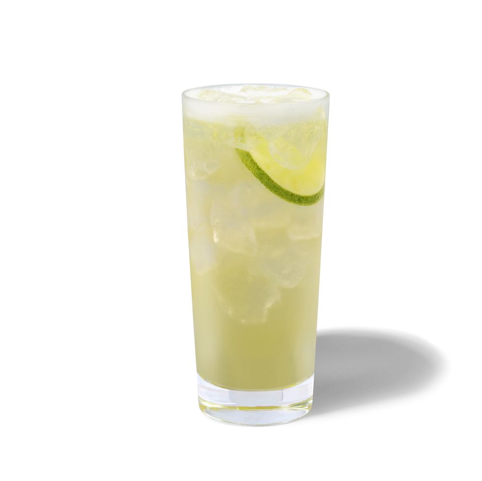 starbucks cool lime refresha drink pictured in a glass with ice and limes