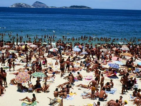 Copacabana, Rio de Janeiro Gezinnen zwemmers en zonaanbidders kruipen allemaal bij elkaar op het Copacabanastrand in Rio de Janeiro Copacabana bestaat uit een halvemaanvormig strand met hotels restaurants bars en winkels en is wellicht het beroemdste strand ter wereld